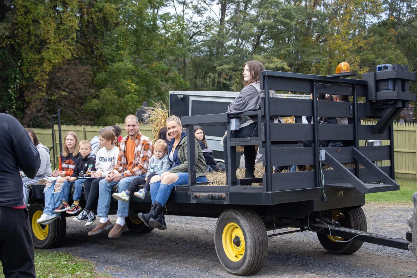 Families riding the hay wagon in daylight on Children’s Day at Headless Horseman